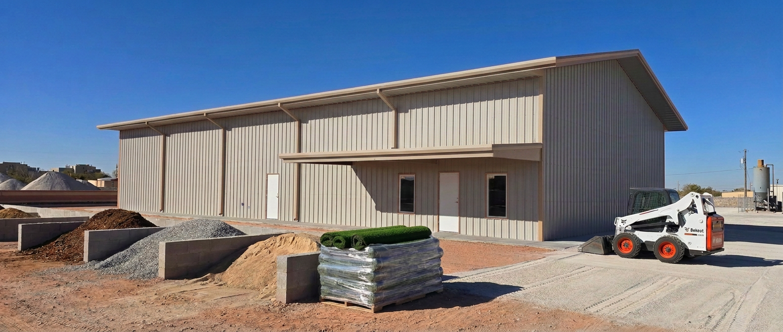 EquipScape Montana Avenue yard in El Paso — branded turf rolls on pallets, Bobcat skid steer, mulch, gravel and pavers ready to load